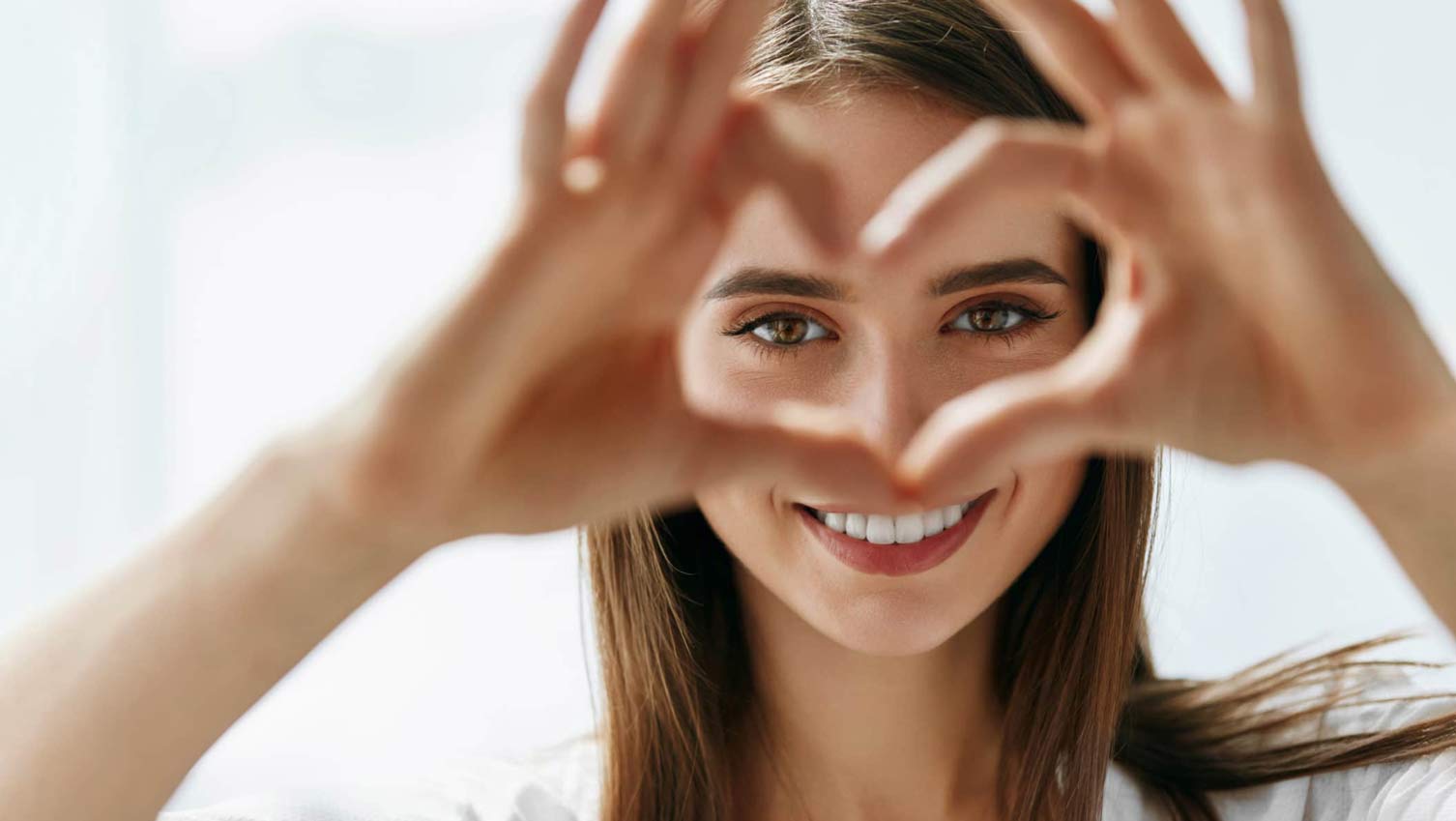 Woman Holding Heart Shaped Hands Near Eyes